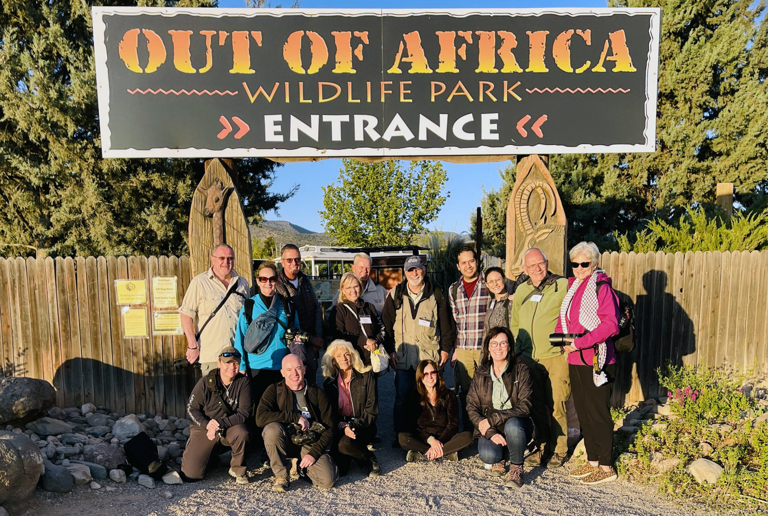 Participants from the photo workshop pose in front of the Out of Africa Park entrance sign.
